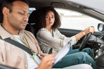 Driver Woman Failing Driving Test Looking At Instructor In Car