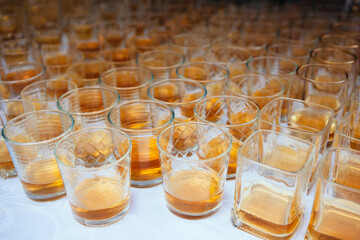 Hard strong alcoholic drinks and distillates in glasses in assortment: vodka, cognac, tequila, scotch, brandy and whiskey, grappa, liqueur, vermouth, tincture, rum. Brown background