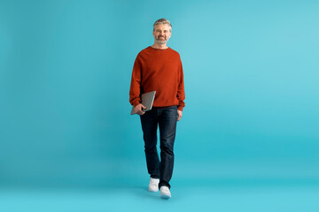 Handsome mature man with laptop in his hand, copy space