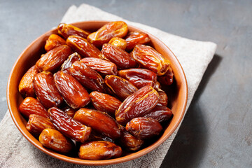 Delicious dried dates on a plate. Pitted dates on a dark background. Dried fruits for a healthy diet