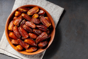 Delicious dried dates on a plate. Pitted dates on a dark background. Dried fruits for a healthy diet