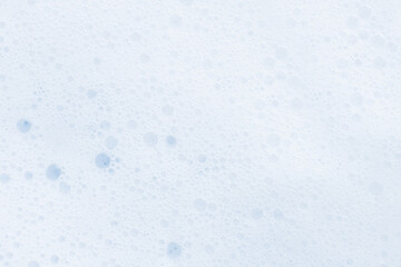 Washing agent foam in a Petri dish. On a blue background.