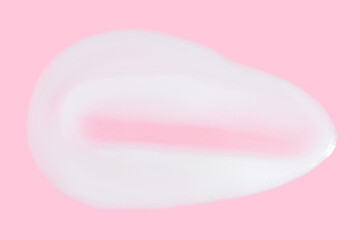 A smear of greasy. cream on a pink background.