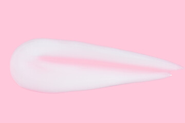 A smear of greasy. cream on a pink background.