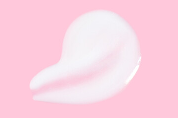 A smear of greasy. cream on a pink background.