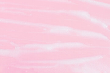 Smeared greasy melting cream. On a pink background.