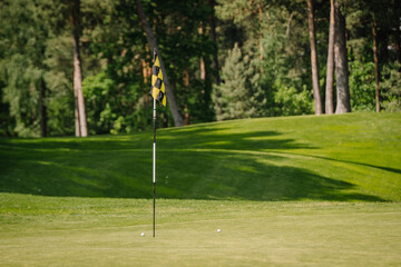 Obraz premium yellow and black checkered flag in golf course