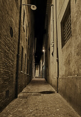 Rimini, Emilia Romagna, Italy: dark narrow alley at night in the old town of the Italian city on the Adriatic sea coast