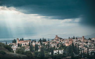Views over Albaicín, Granada. The picture portrays a captivating evening scene with an approaching thunderstorm