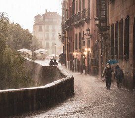 Figures scurrying along the old streets of an European city, seeking shelter from the rain under their unfolded umbrellas 