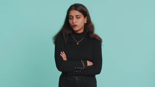 Indian pretty woman shakes finger and saying No, be careful, scolding, giving advice to avoid danger mistake, disapproval sign. Young girl isolated alone on blue studio background. People lifestyle