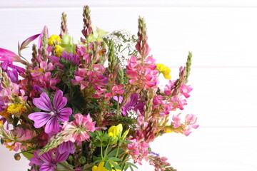 Wild field flowers bouquet, on wooden background, copy space