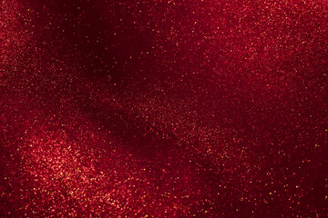 Abstract strains of gold particles in a red liquid. A mysterious glistening fluid background....