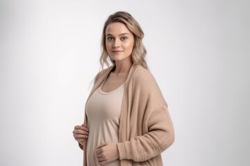 Fototapeta premium pregnant woman in beige sweater on a white background.