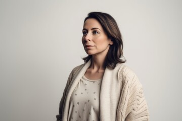 Obraz premium Portrait of a beautiful woman in a sweater on a gray background