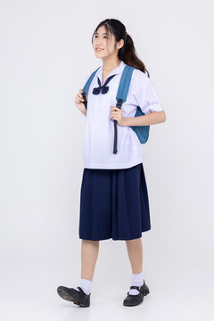 Full Body Portrait Of Happy Asian Student Girl With Uniform Isolated On White Background.