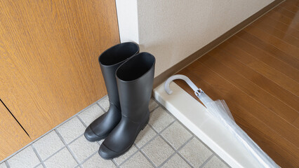 梅雨のイメージ｜玄関の長靴とビニール傘