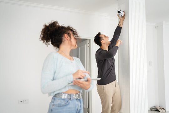 man and woman couple wife husband set up surveillance security camera