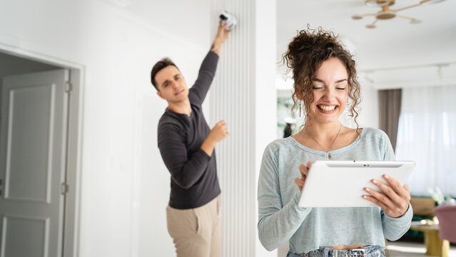 man and woman couple wife husband set up surveillance security camera