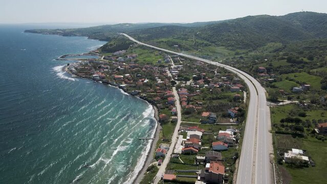 Aerial view of a serpentine road following the coastline along the Marmara Sea, Sevketiye, Lapseki, Turkey.