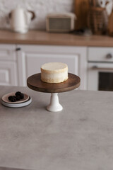 Mini bento cake on a wooden cake bowl. Delicious dessert. The process of decorating a cake with berries