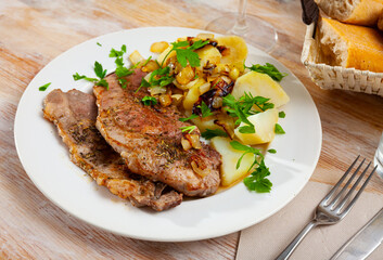 Grilled pork chop steak on plate served with boiled potatoes