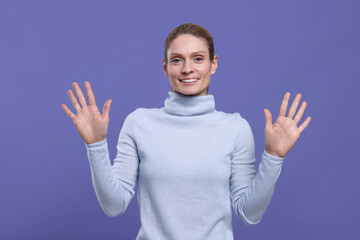 Naklejka premium Woman giving high five with both hands on purple background
