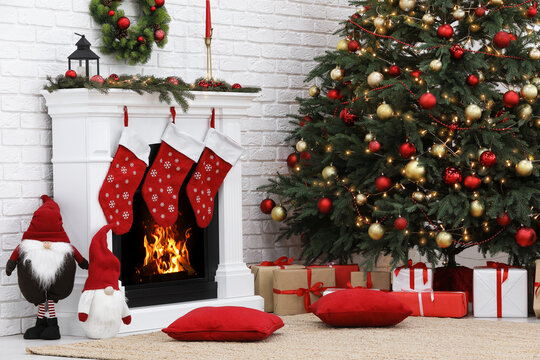 Cosy room with tree and fireplace decorated for Christmas. Interior design