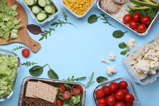 Flat lay composition with different containers of fresh products on light blue background. Space for text