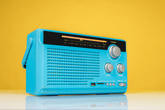 Close-up of old radio receiver light blue color on yellow background.