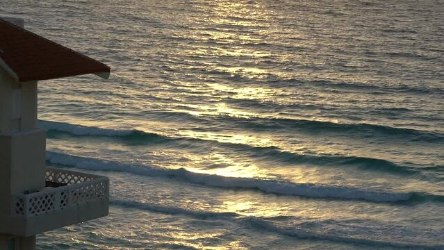 A Cancun senet with sun shining on the water next to a hotel