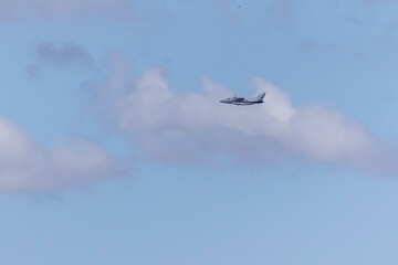 A twin-engine plane flying in a blue sky. Transport. Air travel.