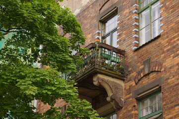 Balcony in an old building, surrounded by greenery.