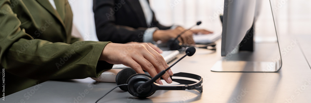 Aufkleber panorama focus hand holding headset on call center workspace desk with blur background of operator t