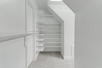 Fototapeta premium Modern Empty Primary Bedroom Closet Interior with Shelves