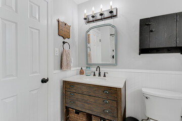 Modern Farmhouse Hall Bathroom Interior with Wood Vanity and Arch Mirror