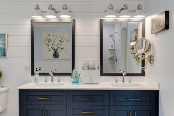 Modern Farmhouse Bathroom interior Blue Double Vanity and Mirrors with White Light Sconces
