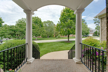 Southern Front Porch with Curved Arch Ceiling and Double White Pillars and Front Lawn