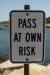 Pass at your own risk sign in a seaport