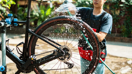 Asian bike mechanic washing a customer's bike.