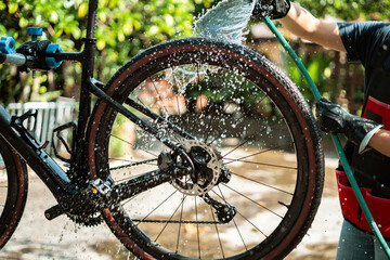 Asian bike mechanic washing a customer's bike.