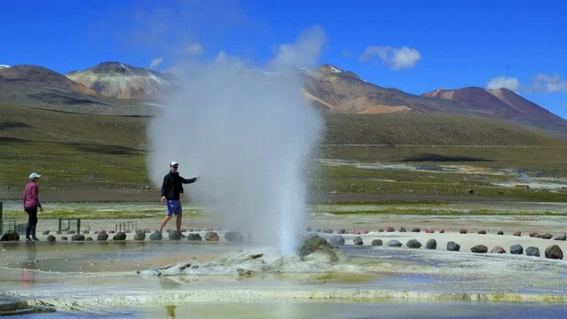 Young Couple Walk Around Steam at El Tatio Geyser, High Altitude Volcanic Activity in Atacama Desert, Chile.