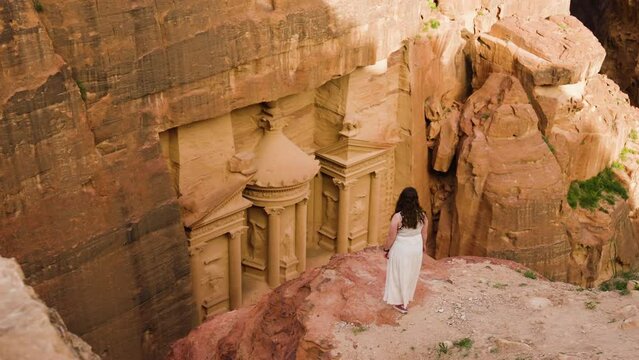 Aerial View Of A Woman On The Cliff Edge Near Historical Ruins In Petra, Jordan. 