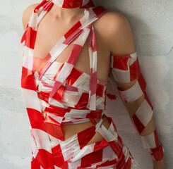 Nude blonde wrapped with red and white scotch tape