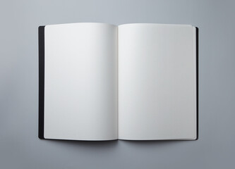 Open blank book with black cover isolated on white background. Top view.