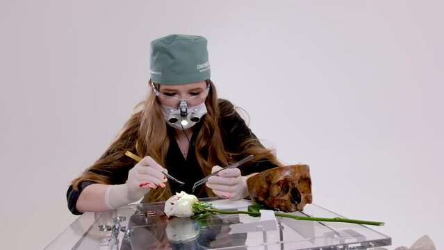 laboratory research study of structure of living organism dissect rose cut sew up tissue female doctor special tool magnification microscope in surgical Illuminator 