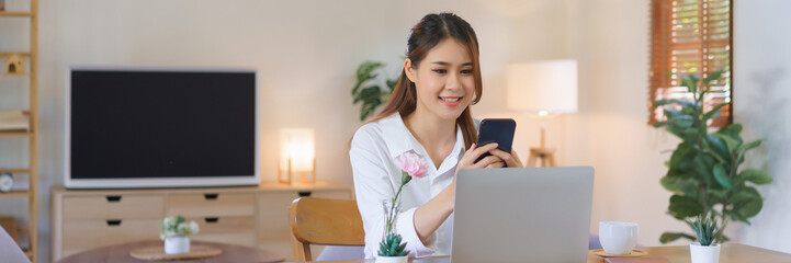 Working lifestyle at home concept, Women use smartphone and laptop to working at modern home office