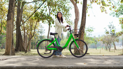 Women pushing bicycle and walking with happiness for resting in the park after cycling to exercise