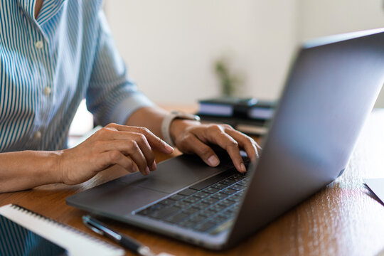 Close up hands of businesswoman typing data on laptop keyboard while working on the desk in office