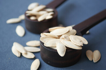 Dry Healthy organic Pumkin Seeds on wooden Spoon .